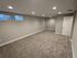 Spacious and inviting carpeted room with modern recessed lighting, perfect for cozy living or entertainment.