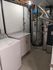 Sleek utility room featuring modern appliances, a stylish marble countertop, and efficient heating system.