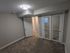 Bright and modern bedroom with plush carpeting, mirrored closet doors, and sleek lighting.