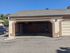 Inviting spacious garage with ample storage potential and a clean, modern exterior design under a clear blue sky.