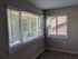 Bright corner of a modern apartment with large windows offering beautiful natural light and a view of lush greenery.