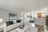 Chic modern living room with plush white sofa, elegant decor, and open-plan dining area in a bright, inviting atmosphere.