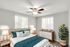 Bright and airy bedroom featuring elegant decor, a cozy bed with plush pillows, and abundant natural light from large windows.