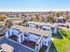 Aerial view of a charming residential complex surrounded by lush greenery and a tranquil neighborhood setting.