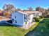 Charming two-story apartment building surrounded by lush greenery and vibrant trees, offering a tranquil living area with ample outdoor space.