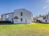 Charming apartment building with modern architecture, nestled in a serene neighborhood with lush green lawns.