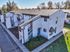 Charming suburban apartment complex with modern architecture, featuring crisp white exteriors, and nestled in a serene neighborhood surrounded by lush greenery.