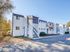 Charming modern apartment complex with white facade and multiple staircases, nestled in a serene wooded area.