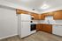 Bright and inviting kitchen with modern white appliances, elegant wooden cabinets, and sleek countertops. Ideal for culinary creativity.