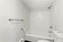 Bright and modern bathroom featuring sleek white subway tiles and a spacious bathtub, offering a clean and refreshing ambiance.