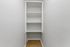 Bright, spacious walk-in closet with minimalist shelving, perfect for organizing your wardrobe and accessories.