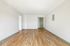 Bright and inviting empty room with polished hardwood floors and soft white walls, offering a blank canvas for personalized interior design.