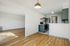 Modern apartment showcasing an open-concept kitchen with sleek appliances, natural wood flooring, and abundant light-filled living space.