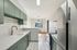 Bright and modern kitchen with sleek stainless steel appliances, mint green cabinetry, and elegant white countertops.