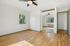 Bright, spacious bedroom with hardwood floors, large window with green views, and mirrored closet doors.