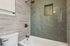Sleek bathroom featuring a modern bathtub with elegant green subway tiles and stylish fixtures.