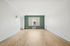 Bright and spacious living room with elegant wooden flooring and a large window offering natural light.