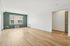 Bright, spacious living room with hardwood floors and a large window, offering abundant natural light in a modern apartment.