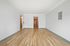 Bright and spacious living room with polished hardwood floors and a minimalist design, perfect for modern living.