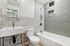 Modern bathroom with elegant gray tiles, sleek fixtures, and a minimalist vanity for a luxurious feel.