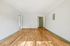 Bright and spacious room with elegant hardwood floors and clean white walls, offering a canvas for your dream living space.
