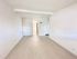 Bright, spacious hallway with modern light flooring and clean white walls, leading to a cozy living area.