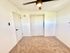 Bright, carpeted room with modern ceiling fan and sleek closet doors, perfect for customization and comfort.