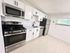 Modern kitchen with sleek stainless steel appliances, elegant white cabinetry, and ample natural light.