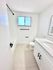 Bright, modern bathroom with sleek white cabinetry, elegant fixtures, and abundant natural light.