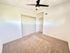 Bright and airy bedroom featuring plush carpet, ceiling fan, and ample closet space.