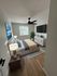 Inviting bedroom with modern ceiling fan, sleek furniture, and ample natural light.
