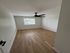 Bright and airy room with elegant wooden flooring and a modern ceiling fan, perfect for a cozy and comfortable interior setting.