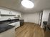 Modern kitchen with granite countertops, sleek black fixtures, and elegant wood-style flooring, perfect for culinary adventures.