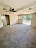 Spacious bedroom with plush carpeting, modern ceiling fan, and abundant natural light through a sliding glass door leading to a serene backyard.