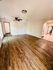 Inviting living area with elegant wooden flooring, ceiling fan, and archway leading to a bright kitchen.