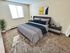 Inviting bedroom with plush carpeting, modern decor, and large window for natural light.