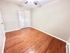 Bright, airy room with elegant hardwood floors and a ceiling fan, perfect for a cozy bedroom or home office.