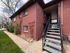 Charming brick apartment entrance with modern outdoor staircase and lush landscaping for a welcoming atmosphere.
