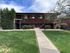 Charming brick apartment building with a modern exterior, lush green lawn, and inviting pathway.