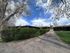 Charming apartment complex surrounded by lush greenery and expansive blue skies, perfect for tranquil living.