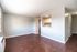Bright and airy living space with modern hardwood floors leading to a cozy kitchen area.