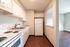 Bright and welcoming kitchen with modern white cabinetry, sleek countertops, and wood-style flooring, perfect for culinary creativity.