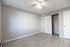 Bright and airy bedroom with sleek wooden floors and a spacious closet, perfect for a modern living setup.