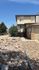 Charming townhouse exterior with a rustic rock garden landscape, nestled in a serene suburban setting.