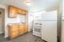 Bright kitchen with modern wood cabinets, sleek countertops, and a spacious layout featuring a large fridge and essential appliances.