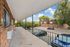 Inviting apartment balcony with scenic views of leafy neighborhood and classic brick buildings, ideal for relaxation.