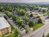 Charming aerial view of a lush, green suburban neighborhood with inviting apartment complexes, ample parking, and scenic mountain vistas.