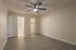 Inviting bedroom with sleek hardwood flooring, modern ceiling fan, and walk-in closet access, exuding comfort and style.
