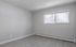 Bright, spacious room with modern flooring and large window, offering a serene view.