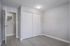 Modern, bright room with sleek light gray walls, glossy wooden flooring, and pristine white doors, creating a fresh and inviting atmosphere.